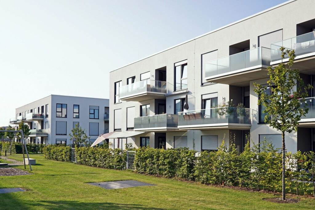 Mehrfamilienhaus mit Balkonen und Glasgeländern