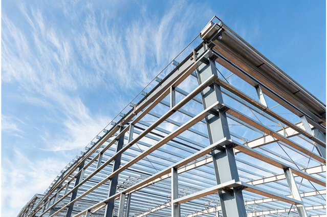 Stahlskelett einer Stahlhalle vor blauem Himmel